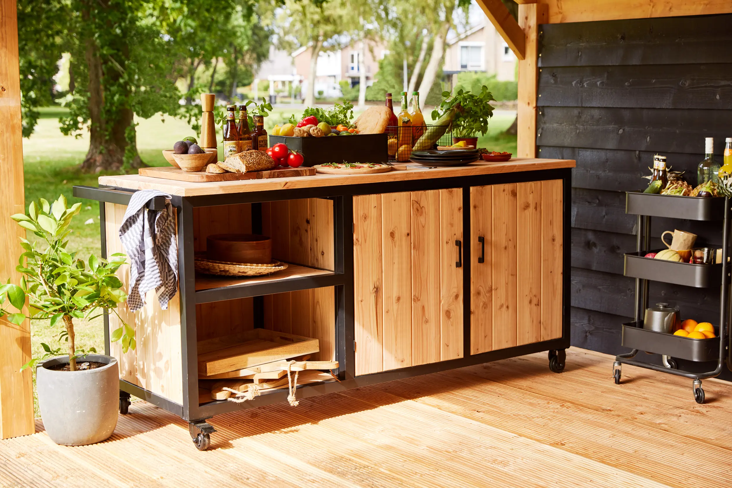 Wooden Acero Outdoor Kitchen Station 190cm featuring a black metal frame on a patio.