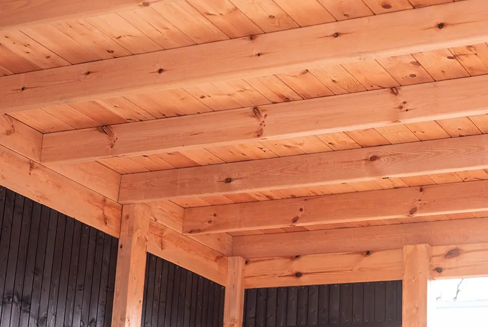 Underneath view of a wooden roof structure showing heavy timber framing built with Ecowood Beam 200x200mm by 4000mm length.