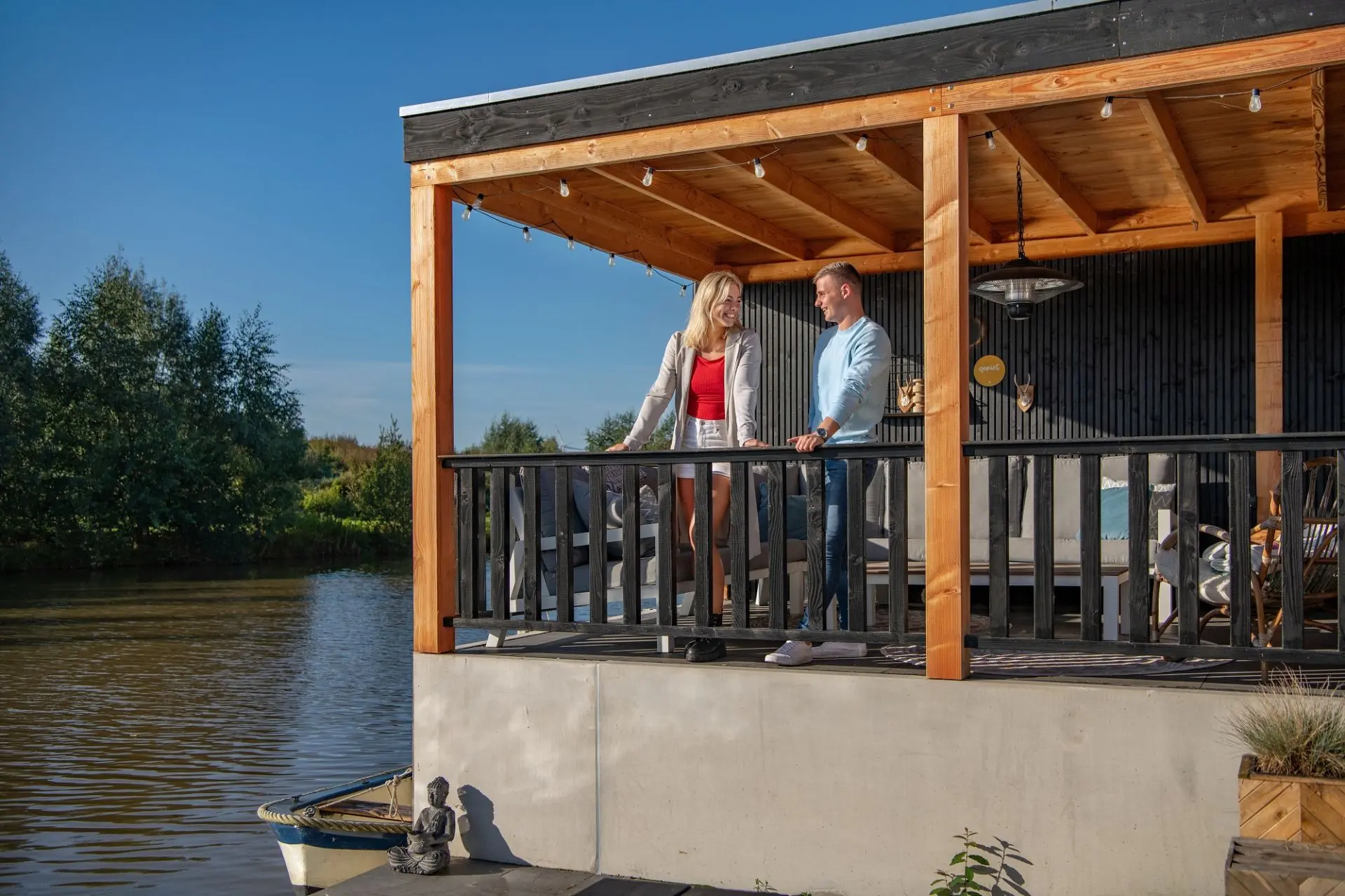 Couple on a waterfront deck featuring black Douglas Fir cladding board on the back wall.