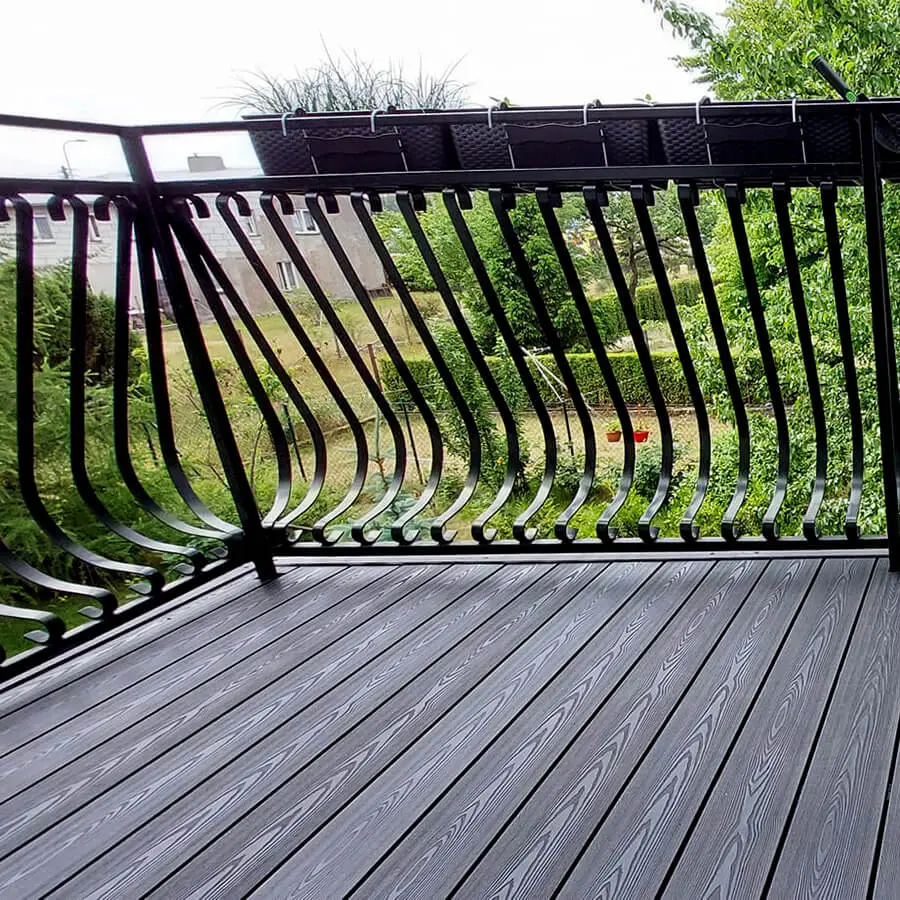 PuraPrime charcoal round hollow composite decking boards installed on an outdoor balcony featuring a black metal decorative railing.