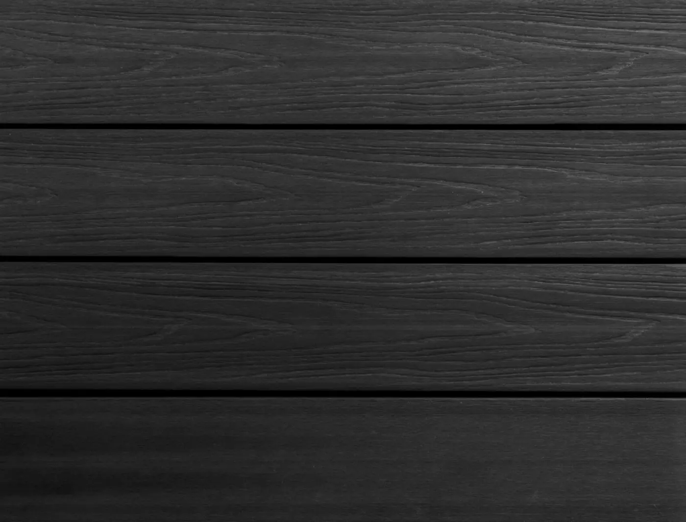 Flat, full-frame texture view of installed PuraShield round hole co-extruded composite decking boards in Ebony Black showing parallel gaps and a natural looking wood grain surface.