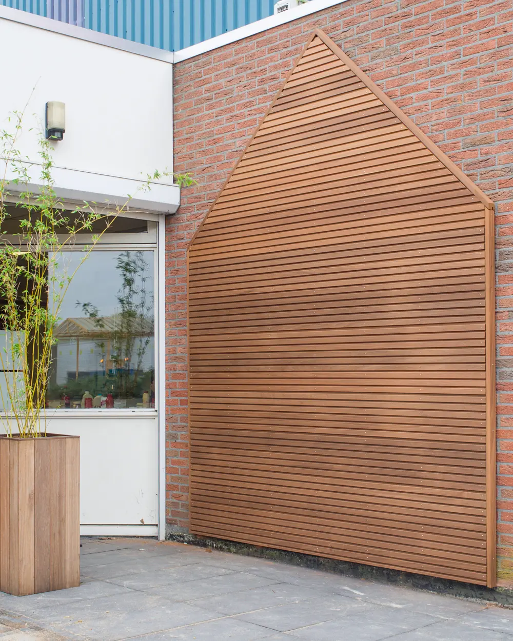 Exterior brick wall feature built with Thermowood Ayous Cladding Board 145x21mm 4500mm.
