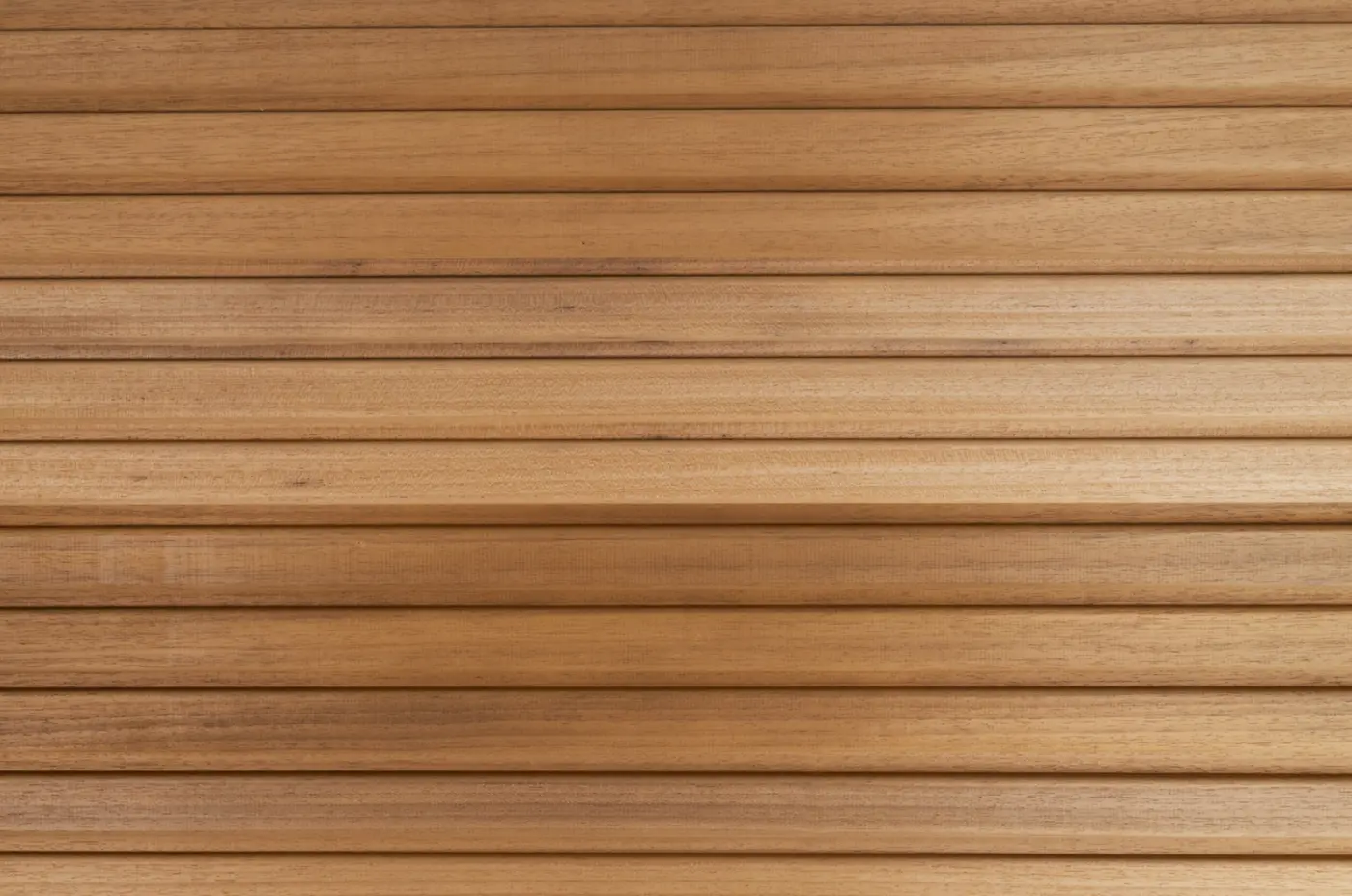 Close-up texture of Thermowood Ayous cladding boards featuring a modern triple slatted profile and smooth, light brown timber grain finish.